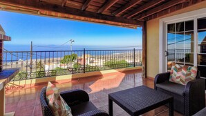 A balcony with wicker furniture, a view of the sea, and a tiled floor. - Rural House Tijoco Bajo & With Jacuzzi Adeje (Adeje)
