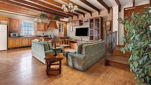 A spacious living area with a wooden floor, a sofa set, a television, and a staircase leading to a second floor. - Rural House Tijoco Bajo & With Jacuzzi Adeje (Adeje)