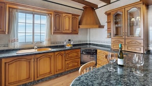 A kitchen with wooden cabinets, a granite countertop, a stove, and a wine bottle. - Rural House Tijoco Bajo & With Jacuzzi Adeje (Adeje)