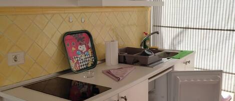 A compact kitchen with a countertop, a sink, and a refrigerator.