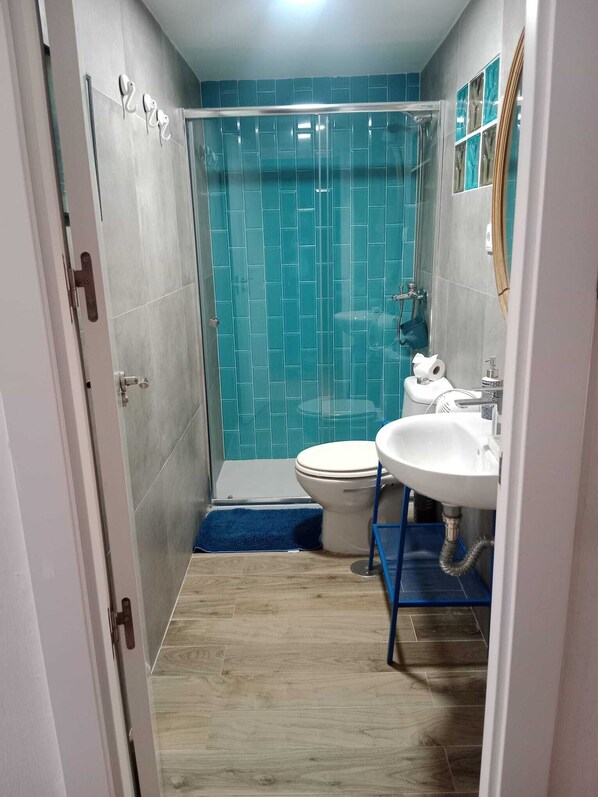 Un baño con ducha, inodoro y lavamanos.