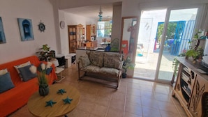 A living room with a sofa, armchair, coffee table, and a dining area with a table and chairs. - House With Exclusive Pool and Garden 7 min Walk From the Beach and the Center (El Campello)