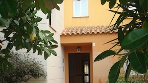 Ein Gebäude mit einer gefliesten Eingangspforte, einer kleinen Veranda und einem Schild mit der Nummer 5.