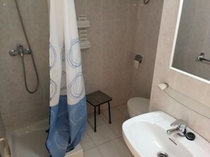 Ein Badezimmer mit Dusche, Toilette und Waschbecken.