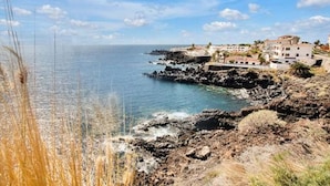 A coastal town with buildings on a rocky cliff overlooking the sea. - Costa Isora First Line and Pool (Guia de Isora)