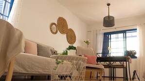 A living room with a sofa, a coffee table, a dining table, and a chair. - Casa Paca - Your Private Oasis in Lanzarote - Paradise by the Sea (Yaiza)
