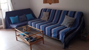 Ένα σαλόνι με έναν καναπέ, ένα τραπεζάκι σαλονιού και διακοσμητικά στοιχεία στον τοίχο.