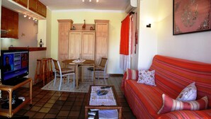 A living room with a television, a sofa, a coffee table, and a dining area with a table and chairs. - Moraira's Lover's Nest (Benitachell)