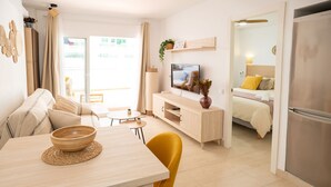 A modern hotel room with a dining area, a bed, a TV, and a kitchen area. - Terrace Retreat -stay in the Heart of Sitges (Sitges)