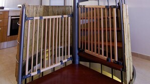 A spiral staircase with a wooden handrail and metal balusters, leading to an upper floor. - Bravo´s Aparment Cotillo 1 (La Oliva)