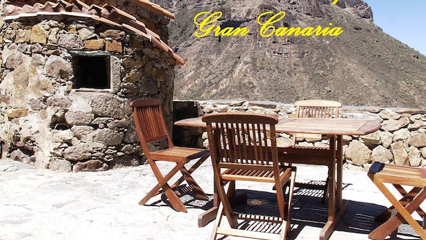 A stone building with a tiled roof and wooden furniture outside. - Rural House Pepita La De Las Flores (Tejeda)
