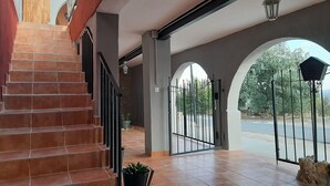 A spacious entrance with a tiled floor, a staircase, and a gated driveway leading to a road. - Casa Rural Garnacha de Borja has a Barbacue and Terrace (Borja)