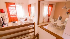 Un appartement moderne doté d’un escalier, d’un espace de vie avec un canapé et d’un coin repas avec des chaises et une table.