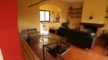 Relax in this inviting living room with a fireplace, comfortable sofa, and dining table.