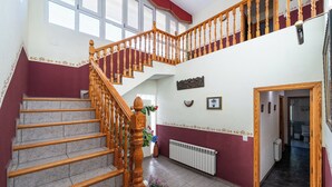 Een meerlaags interieur met een houten trap, een radiator en uitzicht op een badkamer.