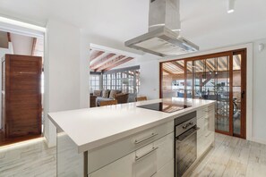 A modern kitchen with a large island, built-in oven, and a view to the outdoor area. - Gran Penthouse Luxury The 307 Parque Royal 1 Wiffi y Jacuzzi (Adeje)