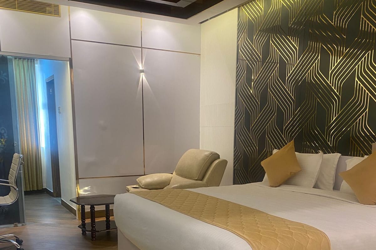 Une chambre d’hôtel moderne avec un grand lit, une table de chevet et une chaise.
