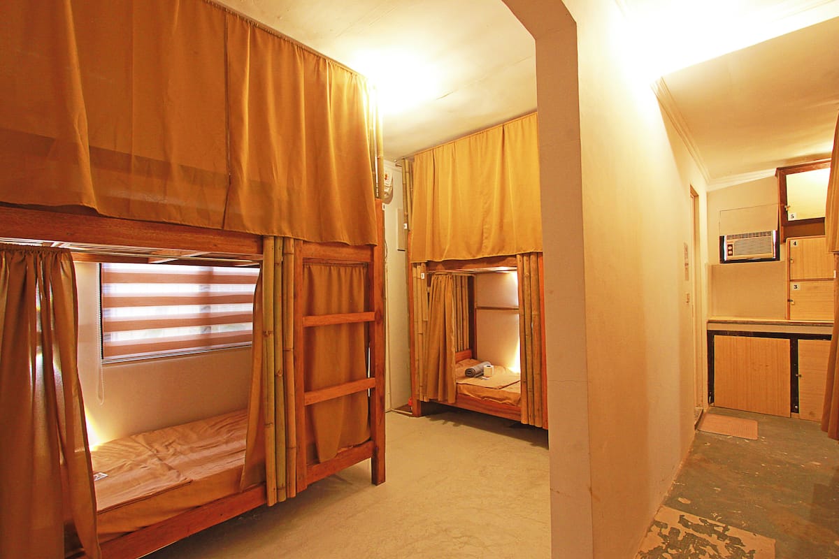 Ein kleines Zimmer mit Etagenbetten, einer Kochnische und einem Badezimmer.