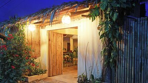 A wooden structure with a door and a light fixture above it. - Yellow Banana Siargao (General Luna)