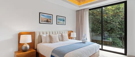 A modern hotel room with a large bed, a ceiling fan, and a view of the outdoors through a sliding glass door.