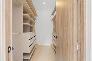 A narrow hallway with built-in shelving units on both sides, leading to a door.