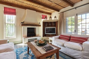 Standard Cottage, Garden View | Living area | Flat-screen TV - Tockie's Cottage (Franschhoek)