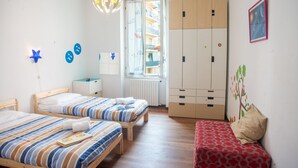 Ein Schlafzimmer mit zwei Betten, einem Kleiderschrank, einem Fenster mit Blick und einer sternförmigen Leuchte.
