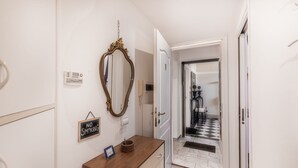 A hallway with a wooden vanity, a large mirror, a 'No Smoking' sign, and a door leading to a room with a checkered floor. - Ardenza s Aires 600 Mt From Sea (Livorno)