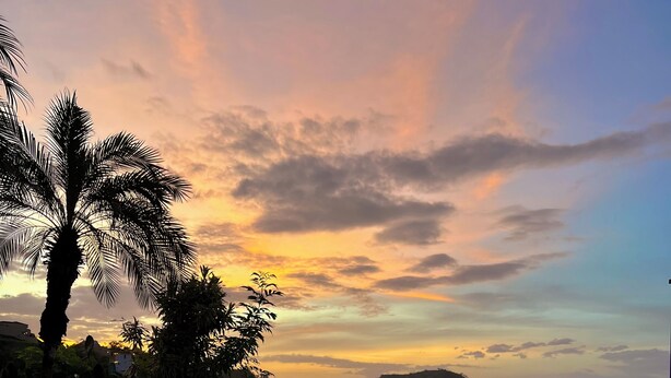 An infinity pool with a view of a sunset and mountains. - Majestic Oceanview Condo with King Beds (Playas Del Coco)