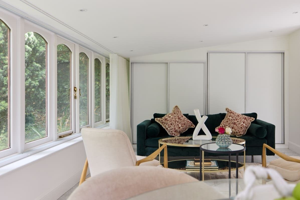 A modern living room with a green sofa, a white chair, and a coffee table.