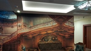 Una stanza con pannelli in legno decorati, una scala e un’area salotto con due poltrone e un tavolo.