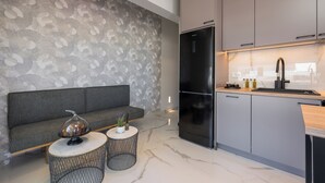 A modern kitchen with a built-in refrigerator, grey cabinets, and a marble countertop. - Orama Luxury Apartments (Chania)