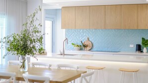 Una cocina moderna con armarios de madera, un backsplash tipo espiga y una isla central con taburetes.