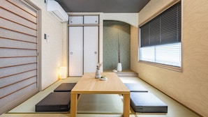 A traditional Japanese room with tatami flooring, a low wooden table, and sliding doors. - JAPAVISTA Yamato (Osaka)