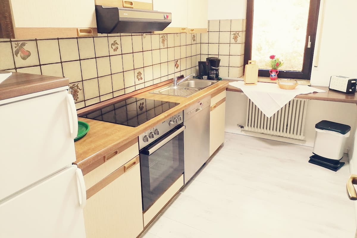 A compact kitchen with a stove, sink, and refrigerator.