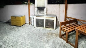 Pequeño espacio cerrado con suelo de baldosas, un banco de madera, un lavamanos y un armario.
