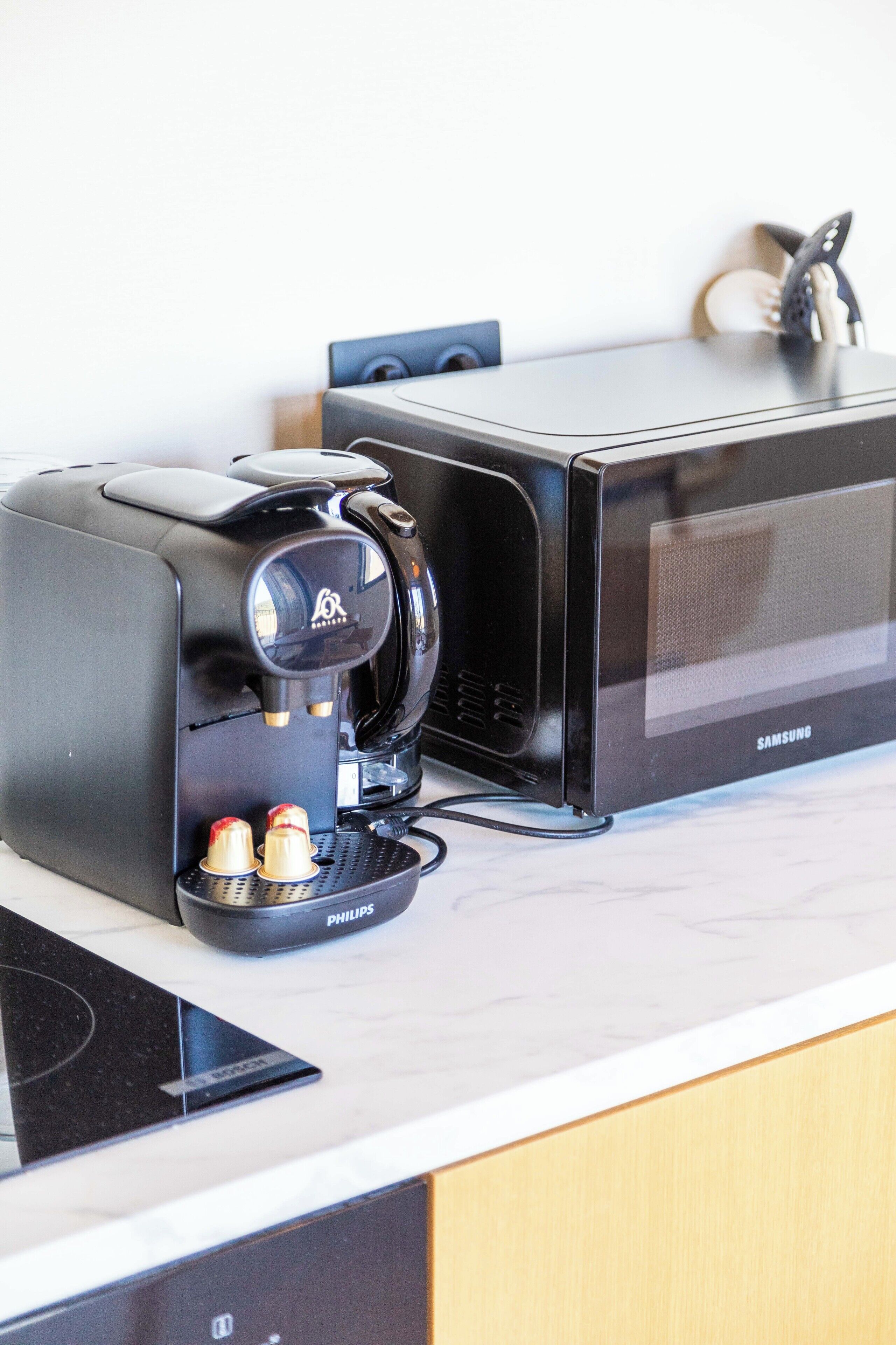 A kitchen with a coffee maker, a microwave, and a toaster.