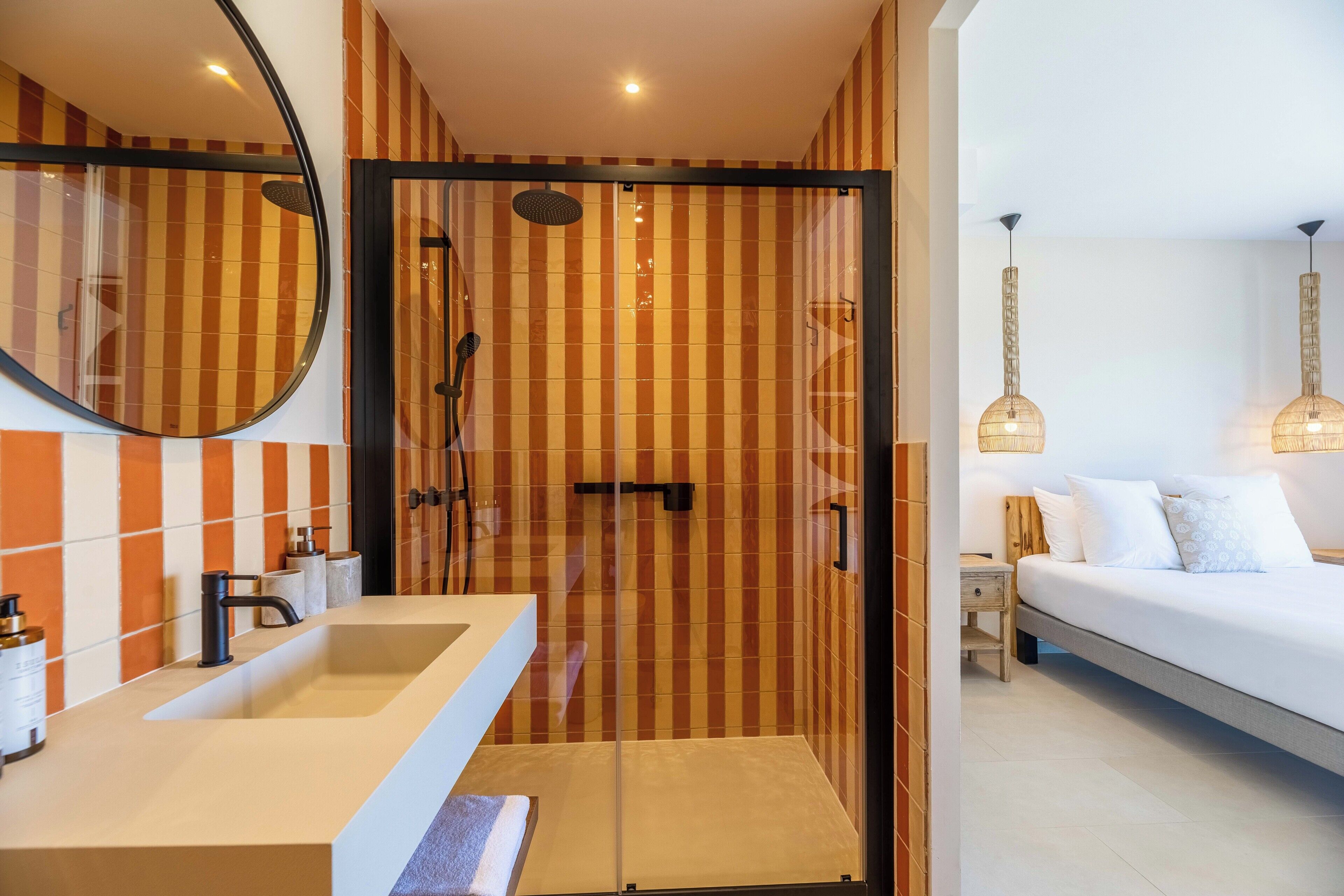A bathroom with a shower, a sink, and a mirror.