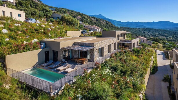 A hillside villa with a swimming pool, outdoor seating, and a view of the mountains. -  Résidence & Villas Oradoro (Belgodere)