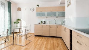 Una cocina moderna con armarios de madera, una mesa de comedor de vidrio y sillas transparentes.