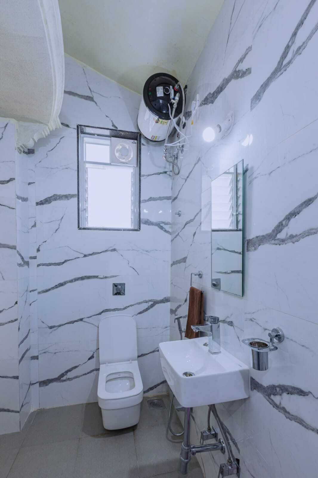 A bathroom with a toilet, sink, and mirror.