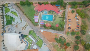 Luftaufnahme eines Resorts mit Schwimmbad, Parkplatz und mehreren Gebäuden.