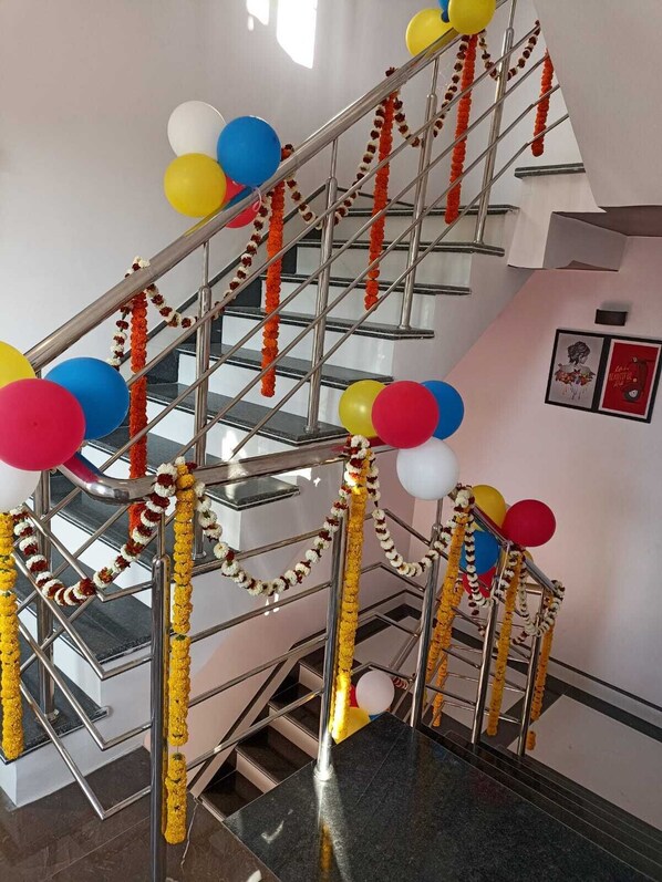 Un escalier avec des rampes en métal, décoré de ballons et de guirlandes colorées.