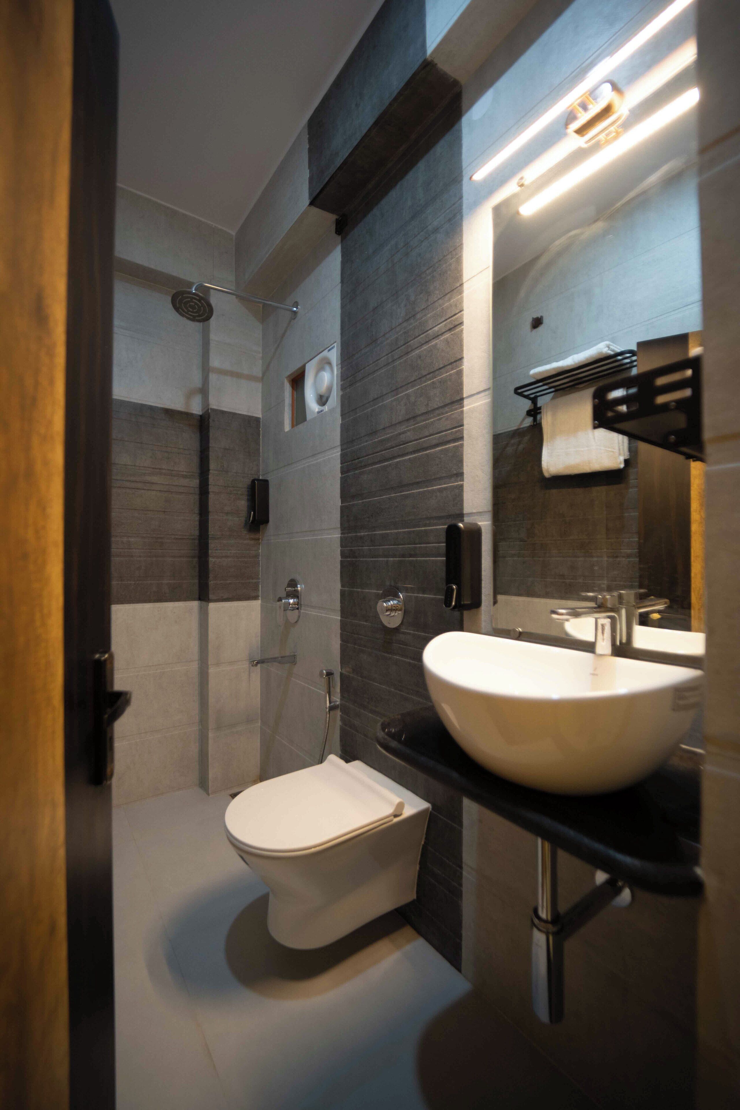 Un baño moderno con ducha, inodoro y lavamanos.