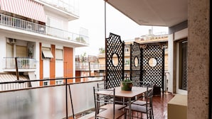 A balcony with a table and chairs, a decorative screen, and a view of neighboring buildings. - Casa Savorelli in Rome (Rome)