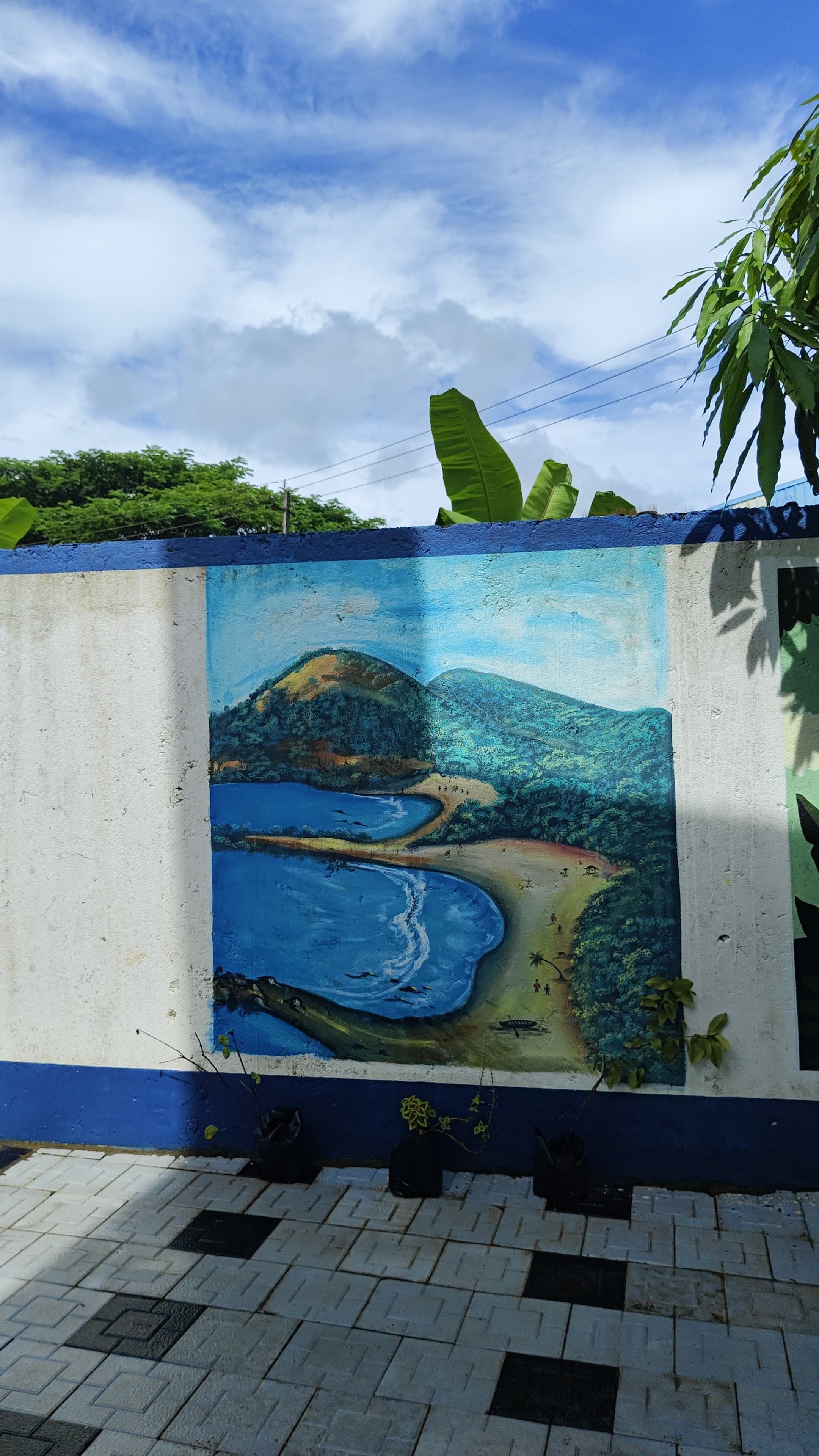 A mural of a coastal landscape with hills, a beach, and a body of water.