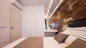 Un dormitorio moderno con una cama grande, una pared de acento de madera y almacenamiento integrado.