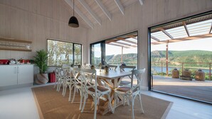 Una cucina moderna con zona pranzo, ampie finestre e vista sull'esterno.