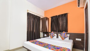 A hotel room with a bed, curtains, a wardrobe, and a colorful bedspread. - DE COMFORT EXECUTIVE (Paud)