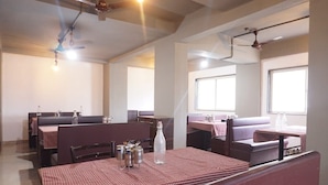 A restaurant with booths and tables, ceiling fans, and large windows. - DE COMFORT EXECUTIVE (Paud)